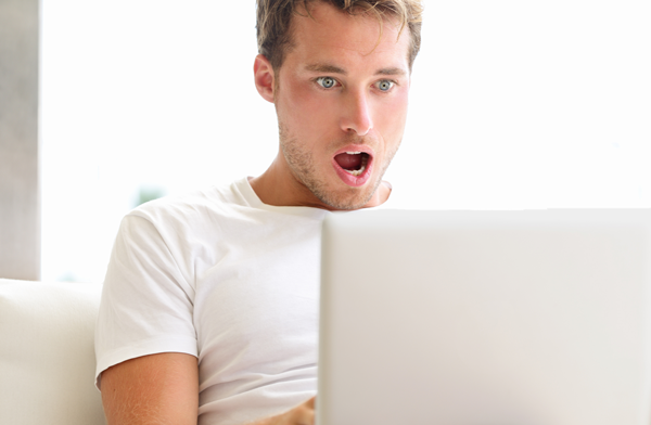 Picture of man looking at something surprising on his laptop